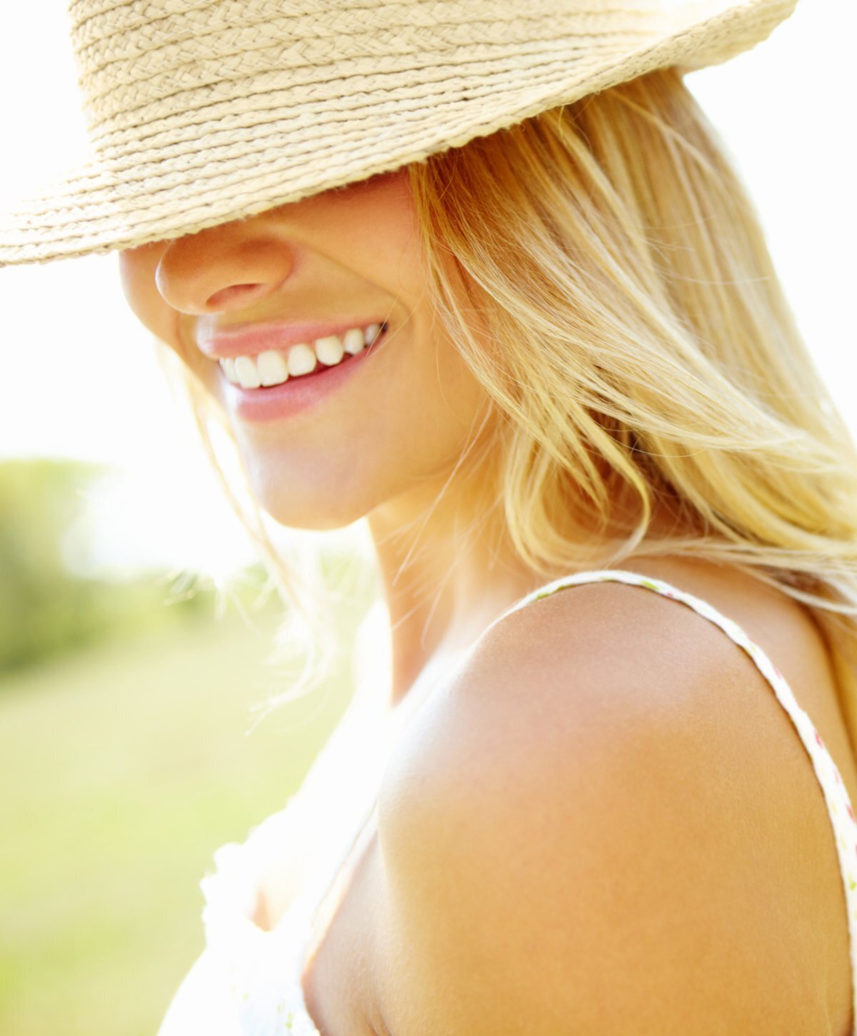 blonde Grand Rapids skinvive patient model smiling in a sun hat