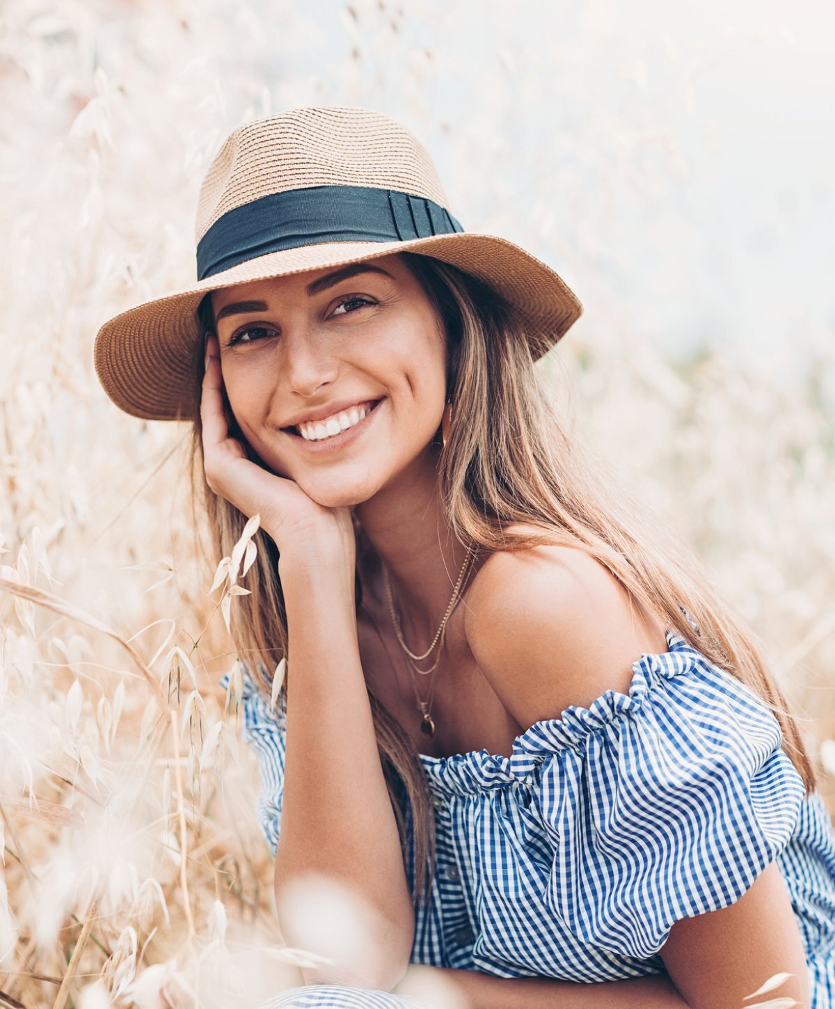 Grand Rapids BOTOX patient model in a blue dress and sun hat smiling