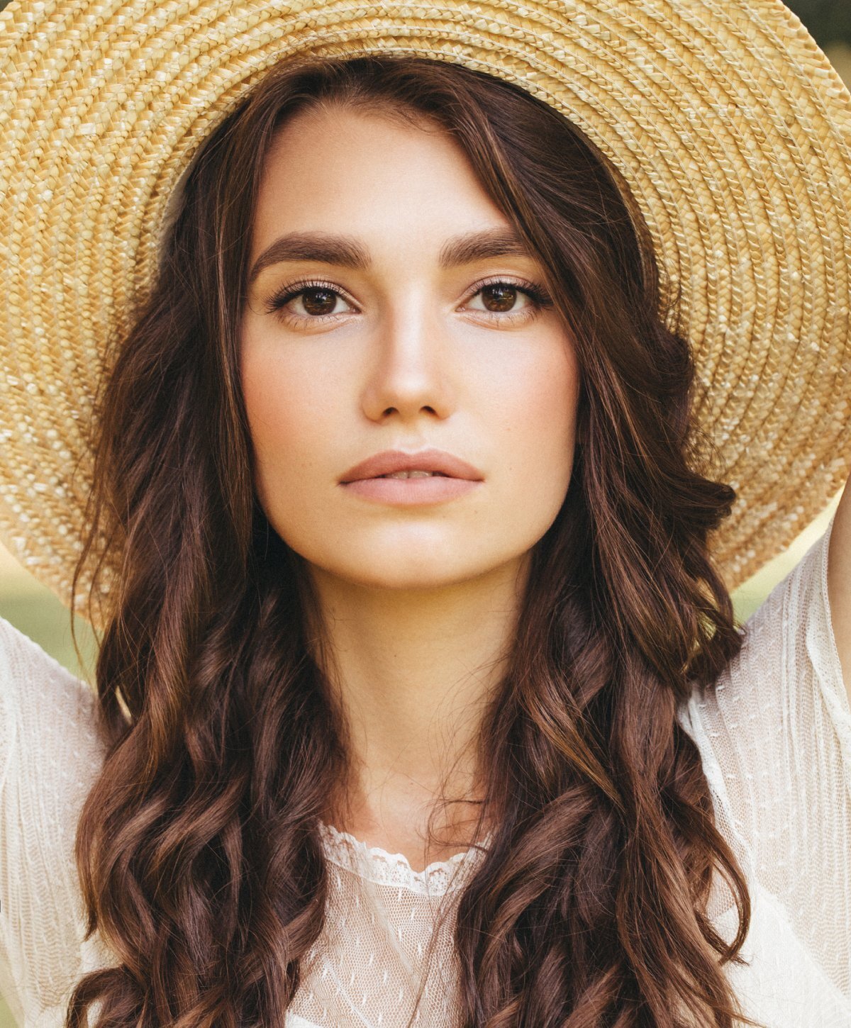dysport patient model in a large straw sun hat and a white top